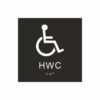 Panneau de toilettes noir et blanc avec un pictogramme représentant un fauteuil roulant ; le texte « hwc » figure sous le symbole et du braille en bas
